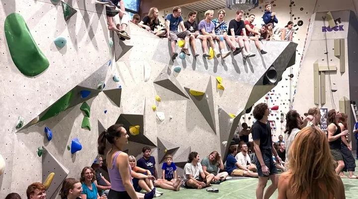 Zuschauende beim Finale sitzen auf und vor dem Pilz in der Boulderhalle | © DAV Karlsruhe